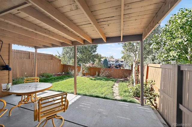 a view of a patio with a table chairs and a backyard