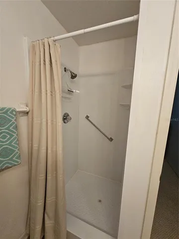 a bed sitting in a bedroom and dresser with wooden floor