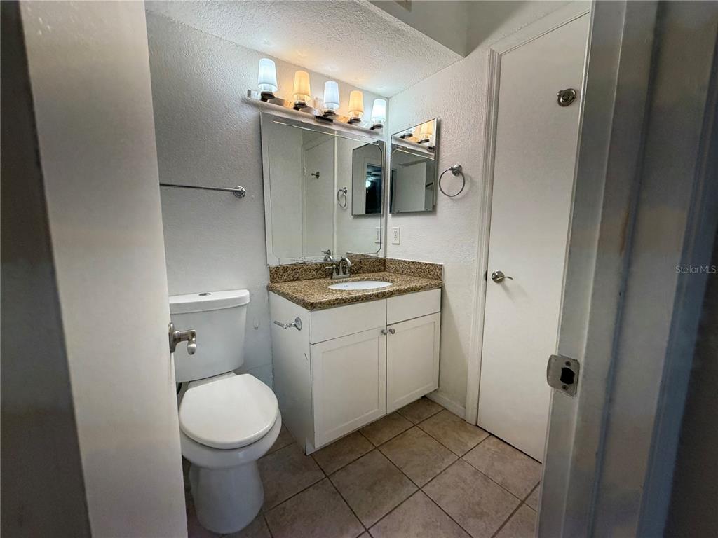 5128 Conroy Road, Unit 25 Orlando, FL 32811 - Photo 15 of 24 a bathroom with a granite countertop sink toilet and shower