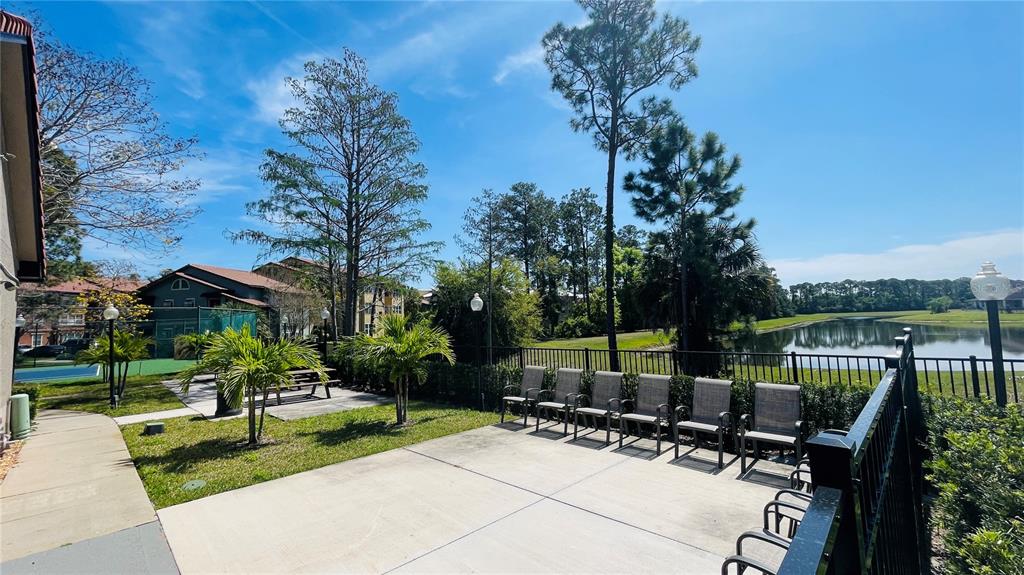 5128 Conroy Road, Unit 25 Orlando, FL 32811 - Photo 19 of 24 a view of a patio with table and chairs potted plants and a palm tree