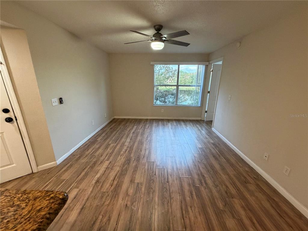 5128 Conroy Road, Unit 25 Orlando, FL 32811 - Photo 7 of 24 an empty room with wooden floor and windows
