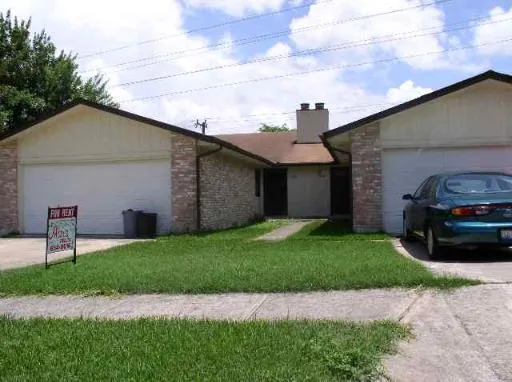 a front view of a house with a garden and chairs