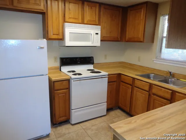 a kitchen with cabinets appliances and a window