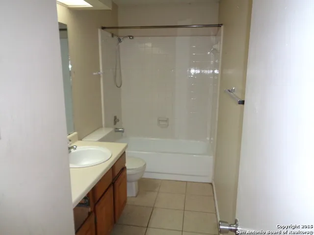 a bathroom with a granite countertop sink a toilet and shower