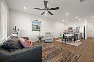 549 Arnold Loop, Unit A Kyle, TX 78640 - Photo 13 of 31 a living room with furniture and a dining table with wooden floor