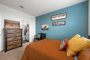 549 Arnold Loop, Unit A Kyle, TX 78640 - Photo 15 of 31 a bedroom with a bed and a painting on the wall