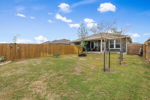 549 Arnold Loop, Unit A Kyle, TX 78640 - Photo 28 of 31 a view of a house with a backyard