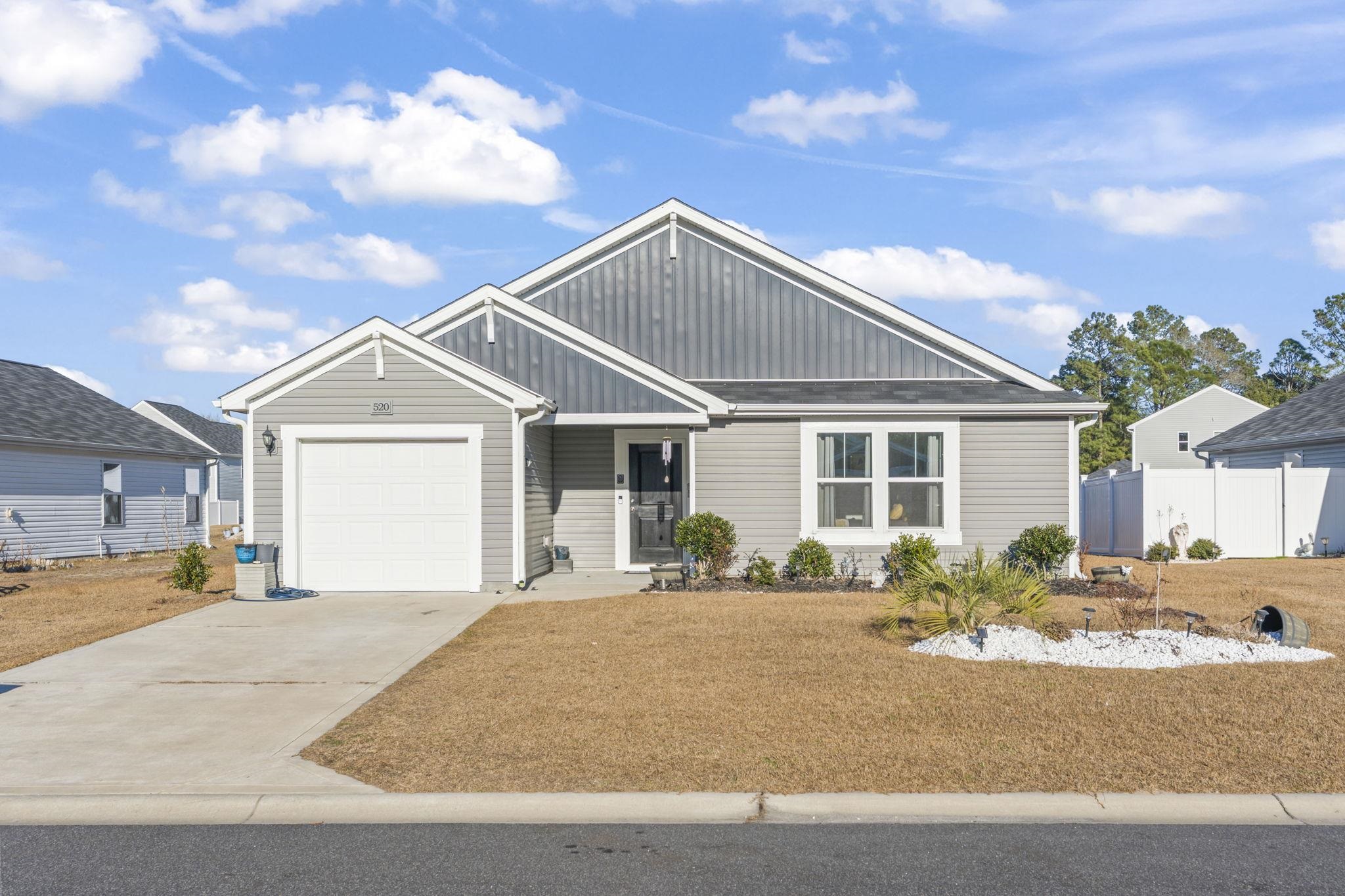 View of front of property with board and batten siding, concrete driveway, and a garage