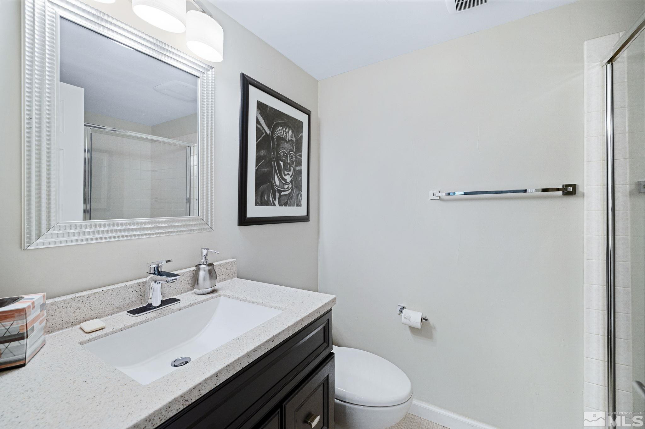 1075 Country Estates Circle Reno, NV 89511 - Photo 30 of 40 a bathroom with a sink mirror and toilet