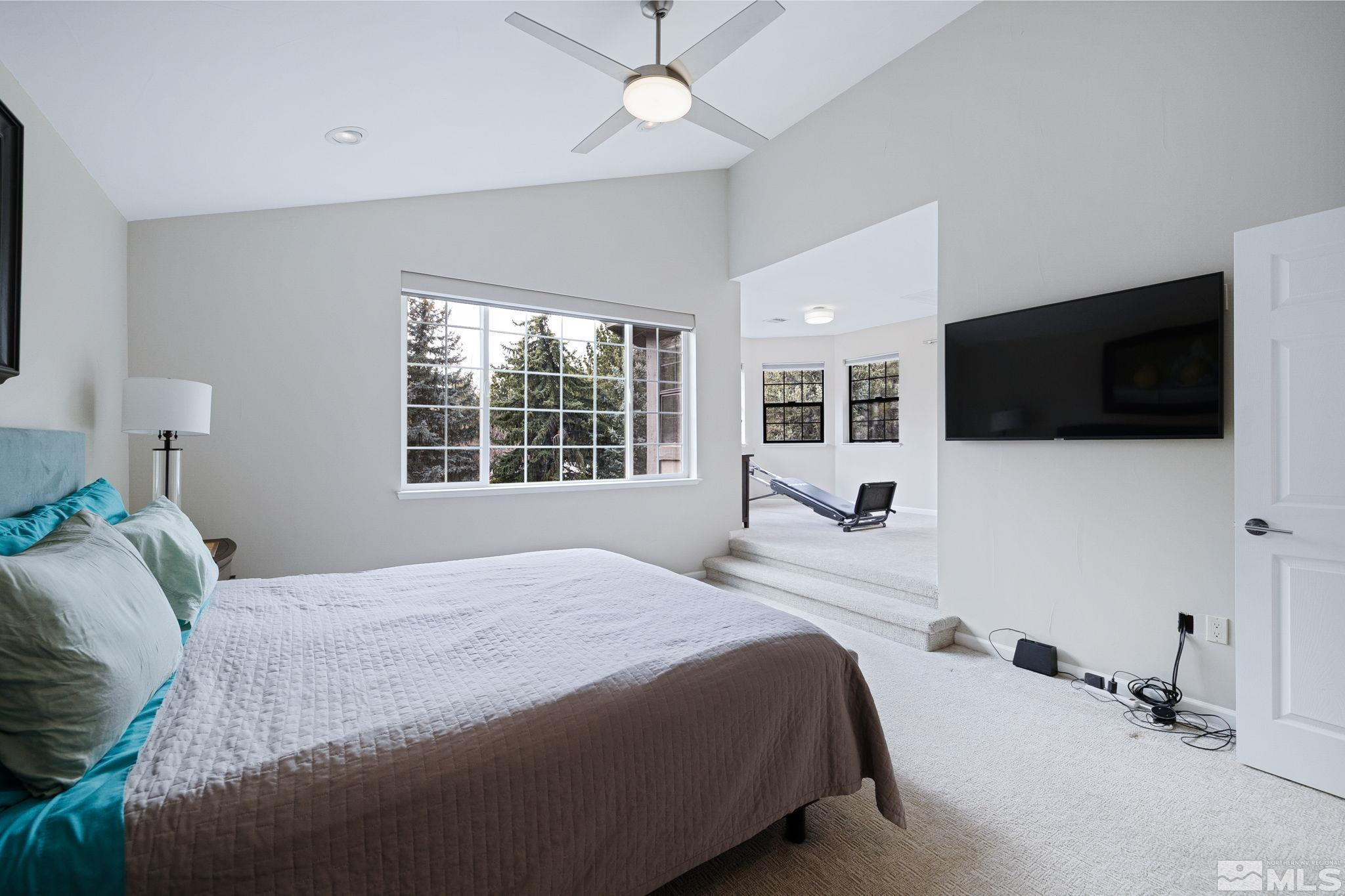 1075 Country Estates Circle Reno, NV 89511 - Photo 31 of 40 a bedroom with a bed a tv and a large window