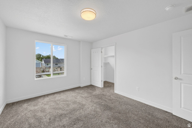 295 Spruce Way Santaquin, UT 84655 - Photo 15 of 32 Bright room featuring white walls, gray textured carpet, and a large window