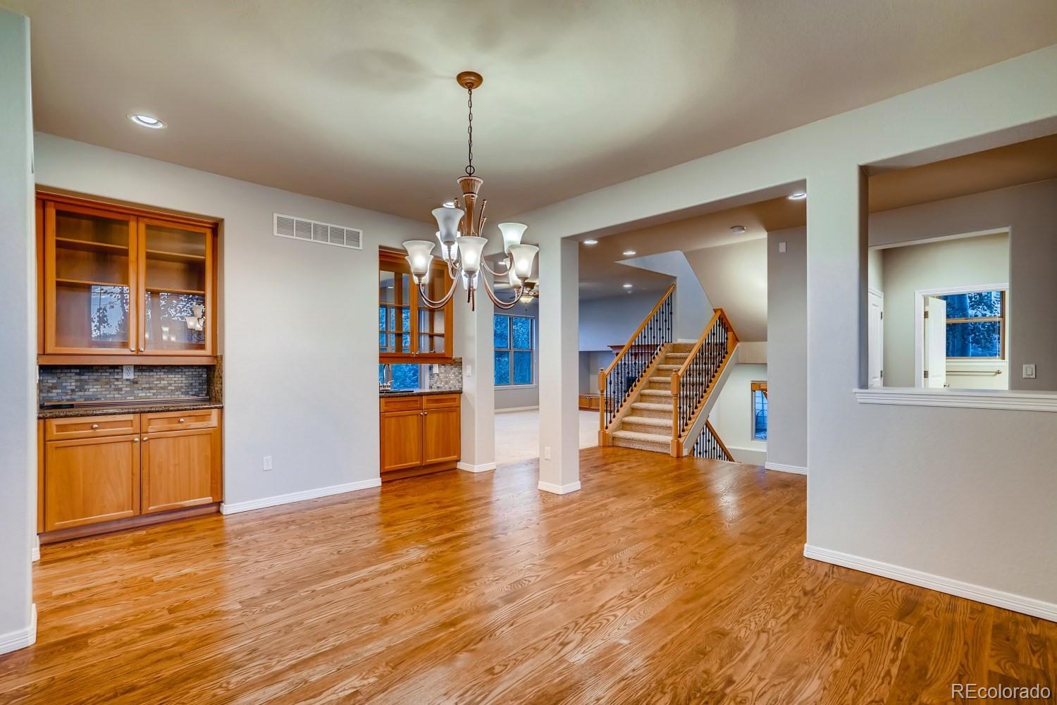 1644 Ridge Trail Lane Castle Rock, CO 80104 - Photo 6 of 38 a view of a room with wooden floor staircase and a kitchen