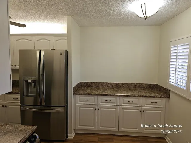 a kitchen with granite countertop white cabinets and white appliances
