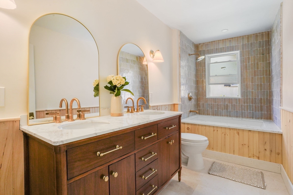 33-35 Russell Street, Unit 1 Brookline, MA 02446 - Photo 9 of 16 a bathroom with a double vanity sink and a mirror