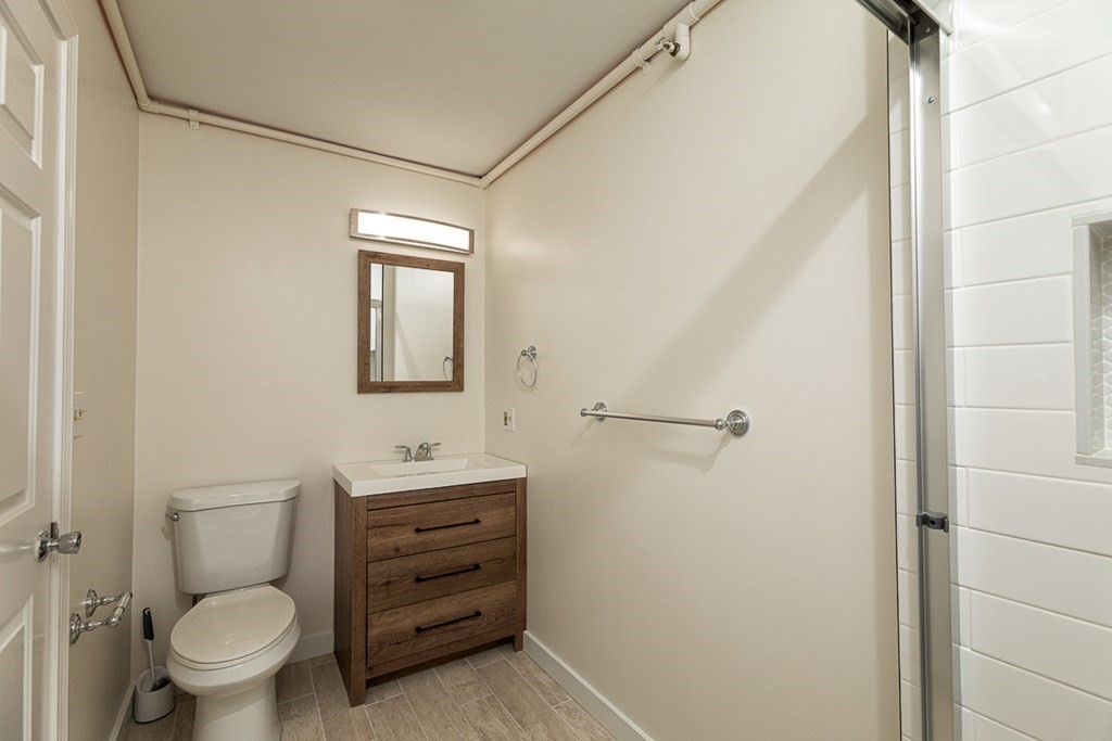 2 Farragut Road, Unit 5 Ipswich, MA 01938 - Photo 13 of 15 a bathroom with a toilet sink vanity and mirror