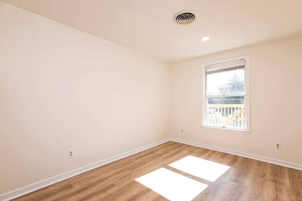 2 Farragut Road, Unit 5 Ipswich, MA 01938 - Photo 10 of 15 an empty room with wooden floor and windows