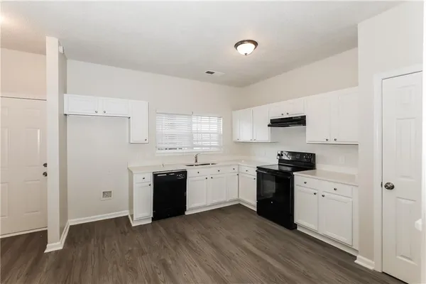 a kitchen with a stove top oven sink and cabinets
