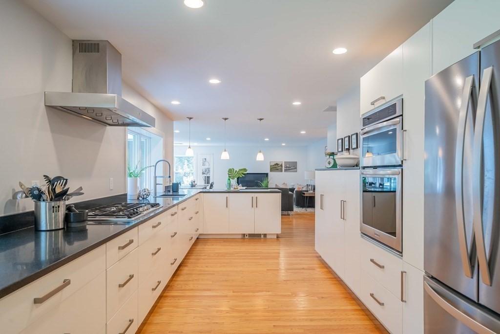 49 Baskin Road Lexington, MA 02421 - Photo 14 of 42 a large kitchen with stainless steel appliances kitchen island a large counter top a stove and a refrigerator