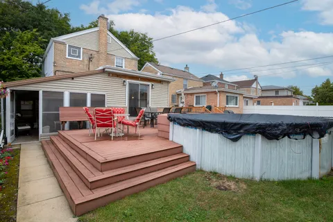 a view of a house with couches chairs and wooden fence