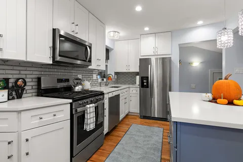a kitchen with stainless steel appliances a stove microwave and refrigerator
