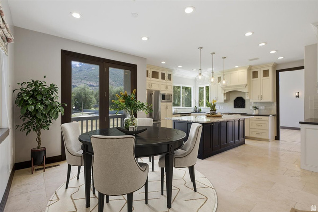 12317 Cypress Point Way Draper, UT 84020 - Photo 7 of 41 Open-concept kitchen and dining area featuring recessed lighting, light-toned flooring, a dark wood kitchen island with a light countertop, and French doors opening to an outdoor space