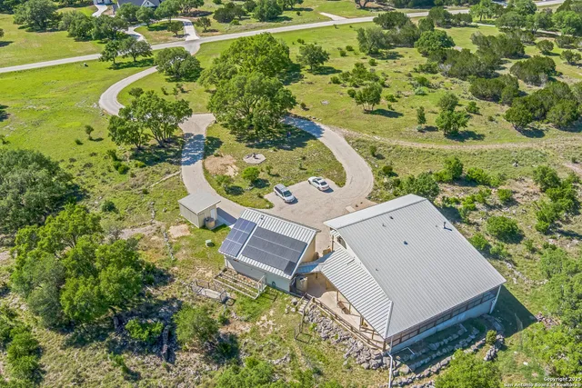 an aerial view of a house with a yard lake and outdoor seating