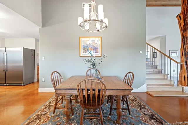 a view of a dining room with furniture a chandelier and wooden floor