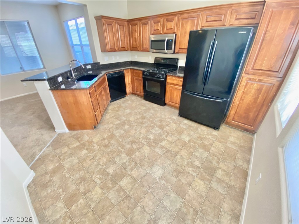 8569 Rhamus Court Las Vegas, NV 89149 - Photo 5 of 35 A well-appointed kitchen offers ample cabinetry, dark countertops, and modern appliances, ready for culinary endeavors.