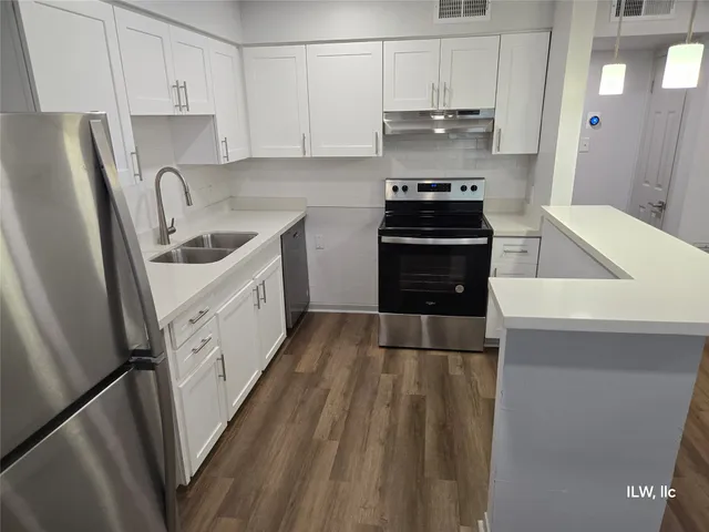 a kitchen with granite countertop a sink stove and refrigerator