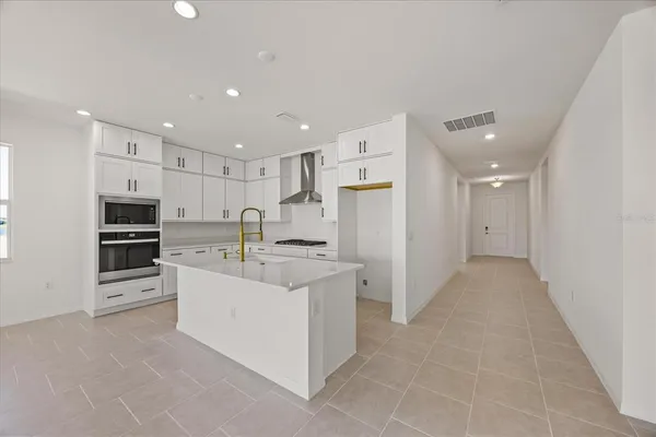 a kitchen with granite countertop a sink stove and cabinets