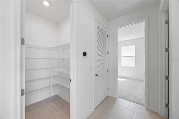 an empty room with an entryway and closet area