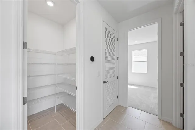 an empty room with an entryway and closet area