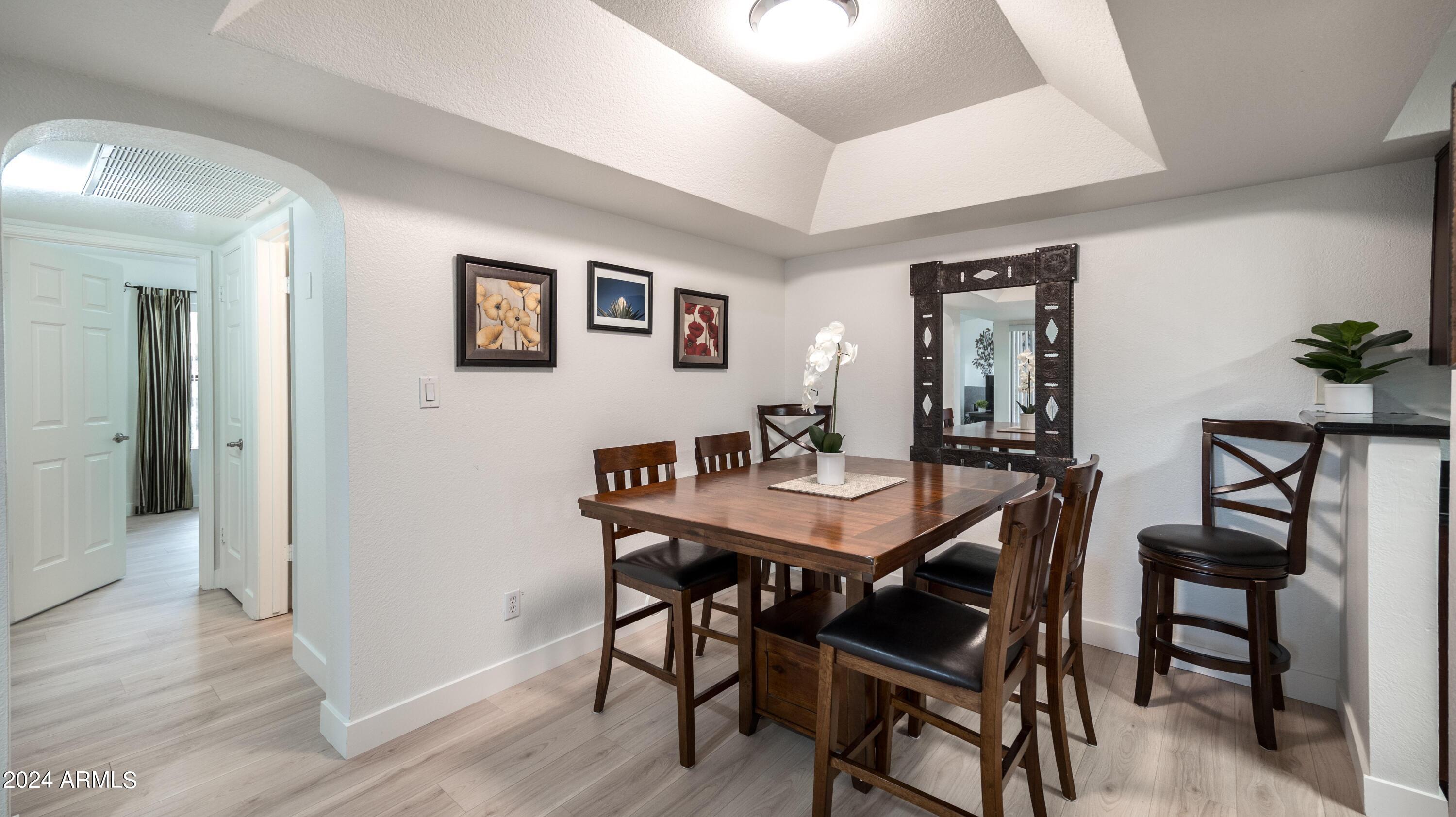 8787 East Mountain View Road, Unit 1034 Scottsdale, AZ 85258 - Photo 14 of 43 a view of a dining room with furniture and wooden floor