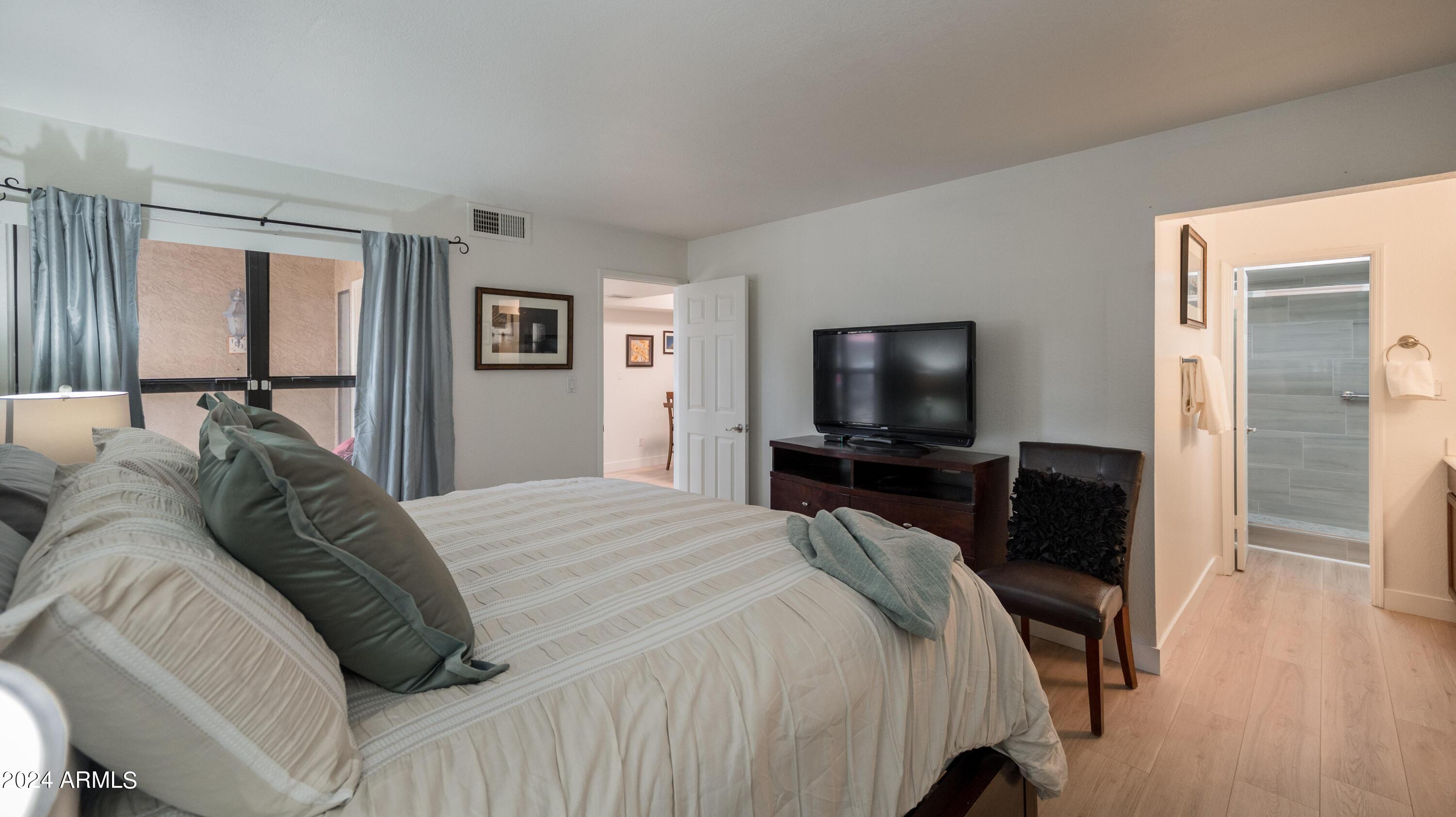 8787 East Mountain View Road, Unit 1034 Scottsdale, AZ 85258 - Photo 20 of 43 a bedroom with a bed and a flat screen tv