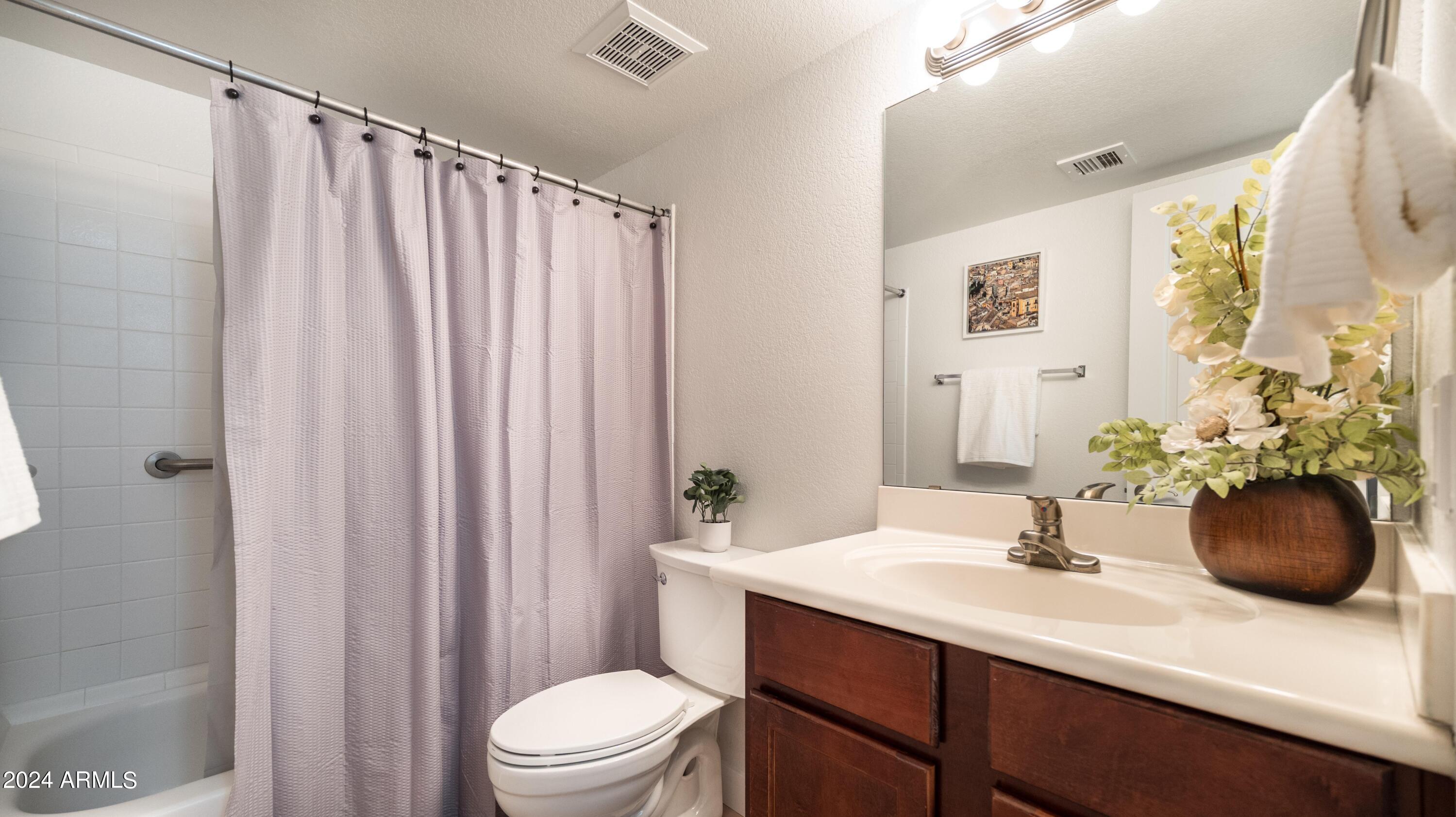 8787 East Mountain View Road, Unit 1034 Scottsdale, AZ 85258 - Photo 26 of 43 a bathroom with a sink a toilet and shower curtain
