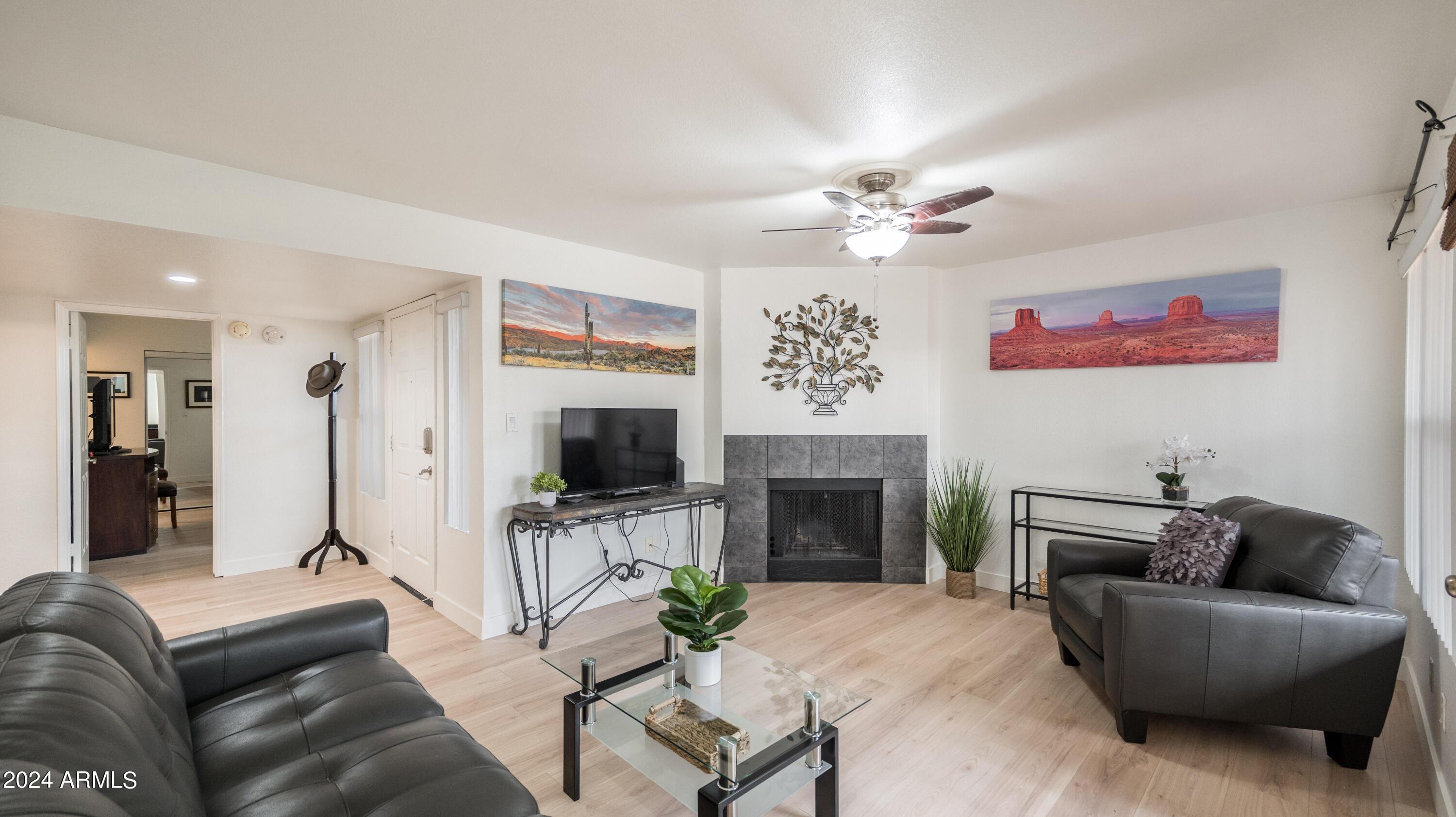 8787 East Mountain View Road, Unit 1034 Scottsdale, AZ 85258 - Photo 5 of 43 a living room with furniture a fireplace and a flat screen tv