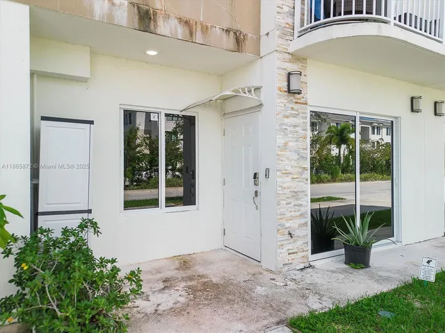an entrance to house with yard and a glass top table