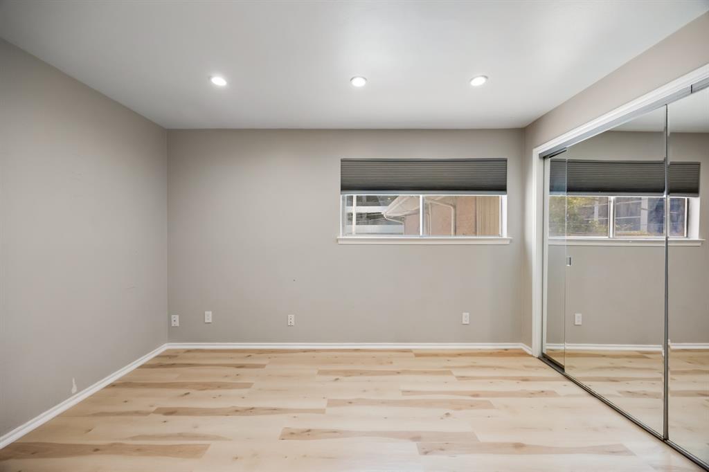 3500 Routh Street, Unit 6 Dallas, TX 75219 - Photo 11 of 17 Secondary bedroom featuring sliding mirror closet doors.