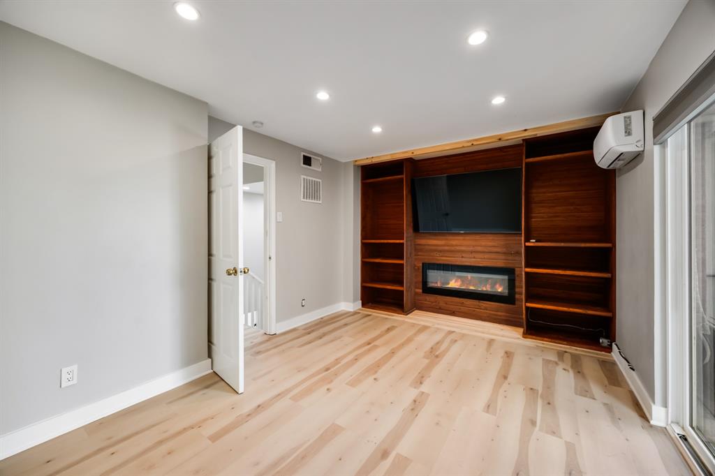 3500 Routh Street, Unit 6 Dallas, TX 75219 - Photo 7 of 17 Primary bedroom with built ins, fireplace, and tv.