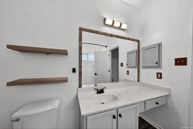 a bathroom with a toilet a sink and mirror