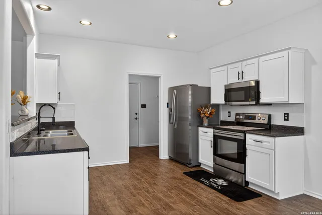 a kitchen with granite countertop a refrigerator and a sink