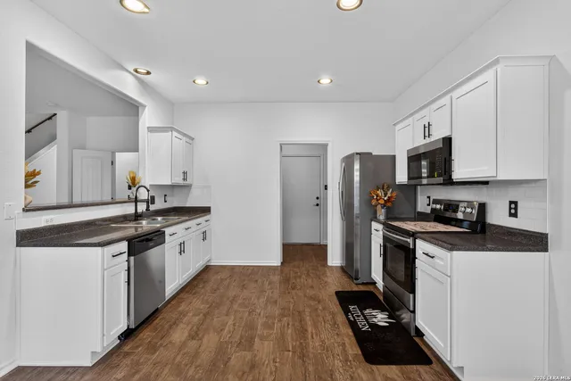 a kitchen with stainless steel appliances a sink stove refrigerator and cabinets