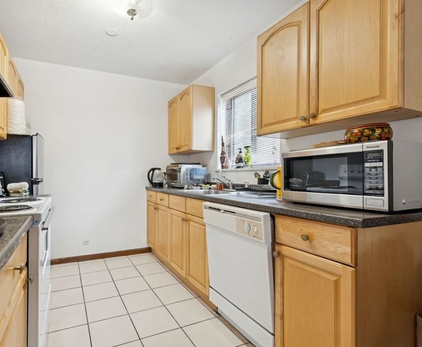 94 Beaconsfield Road, Unit 201 Brookline, MA 02445 - Photo 4 of 13 a kitchen with stainless steel appliances granite countertop a stove a sink and a white cabinets
