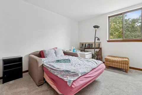 a bed sitting in a bedroom next to a window