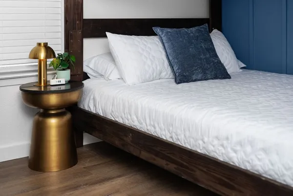 a bed sitting in a bedroom next to a lamp