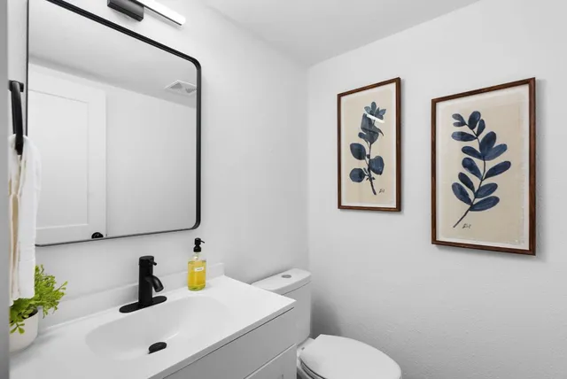 a bathroom with a sink mirror and vanity