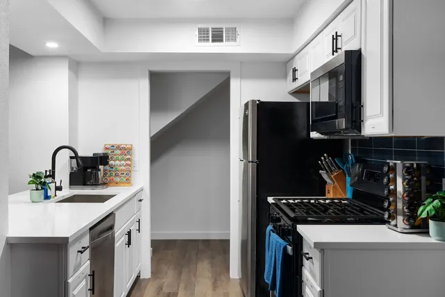 a kitchen with a sink appliances and cabinets