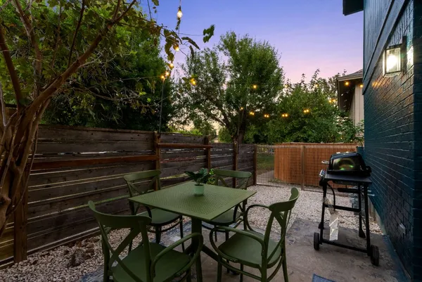 a backyard of a house with table and chairs