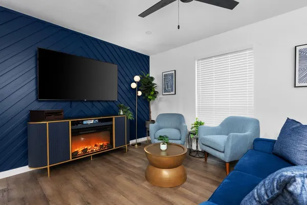 a living room with furniture a flat screen tv and a fireplace