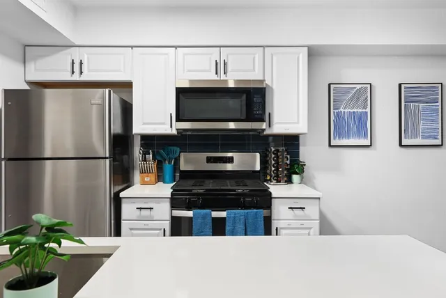 a kitchen with stainless steel appliances a stove a microwave and a refrigerator